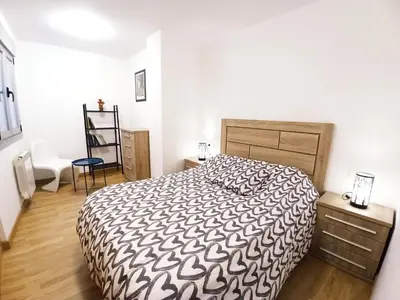 a bedroom with a bed with a black and white comforter at Camiño Vello in Viveiro