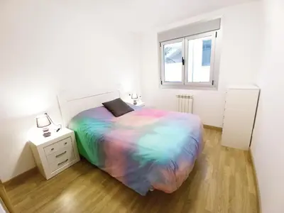 a white bedroom with a large bed and a window at Camiño Vello in Viveiro