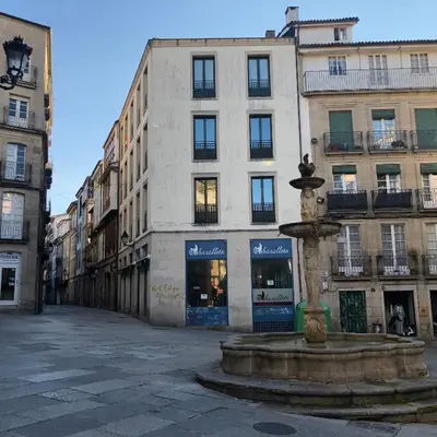 a street with a fountain in front of a building at Afiador in Ourense