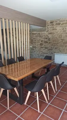 a wooden table and chairs in a room at Veiga da Porta - Casa Rural in Ciquiril