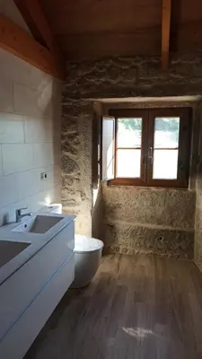 a bathroom with a toilet and a sink and a window at Veiga da Porta - Casa Rural in Ciquiril