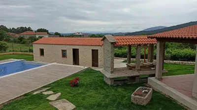 a backyard with a house and a swimming pool at Veiga da Porta - Casa Rural in Ciquiril