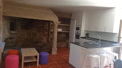 a kitchen with a counter and stools in a room at Veiga da Porta - Casa Rural in Ciquiril