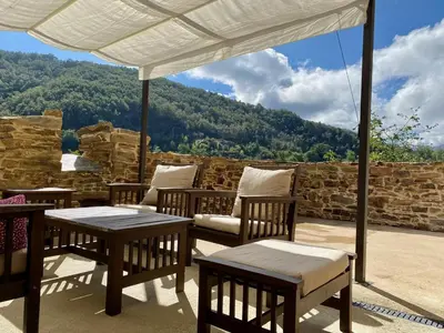 a patio with tables and chairs and a view of a mountain at La Casita de Chocolate - Encanto Rural en Espinoso de Compludo - El Bierzo in Ponferrada