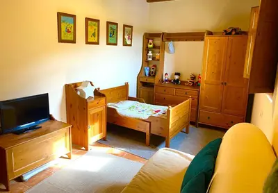 a bedroom with wooden furniture and a tv and a bed at La Casita de Chocolate - Encanto Rural en Espinoso de Compludo - El Bierzo in Ponferrada