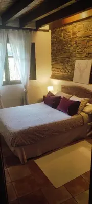 a bedroom with a large bed with a window at La Casita de Chocolate - Encanto Rural en Espinoso de Compludo - El Bierzo in Ponferrada