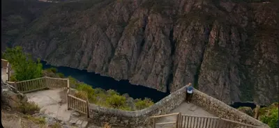 a person standing on a bridge over a mountain at Casa do sequeiro in Parada del Sil