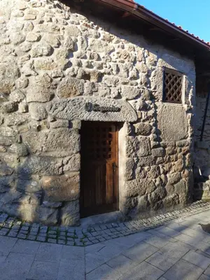 an old stone house with a wooden door at Casa do sequeiro in Parada del Sil