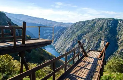 a viewing platform with a view of a river and mountains at Casa do sequeiro in Parada del Sil