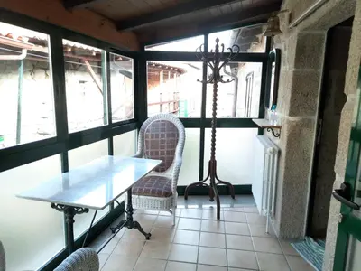 a table and chairs in a room with windows at Casa do sequeiro in Parada del Sil