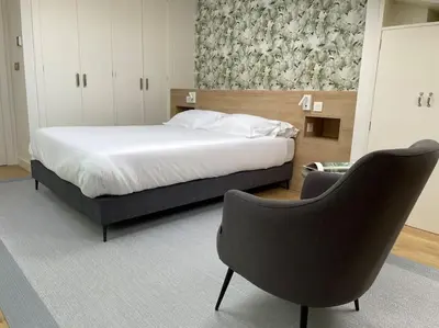 a bedroom with a bed and a chair in it at H7072 Luxury apartments in Santiago de Compostela