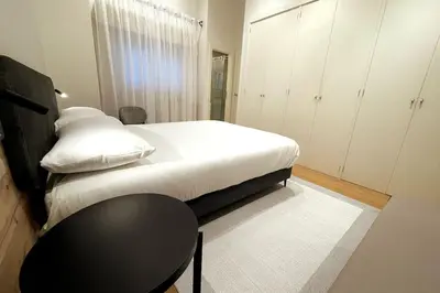 a bedroom with a bed and a table and cabinets at H7072 Luxury apartments in Santiago de Compostela