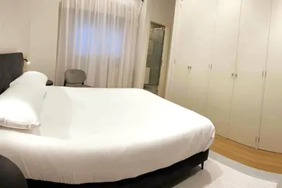 a bedroom with a large white bed and white cabinets at H7072 Luxury apartments in Santiago de Compostela
