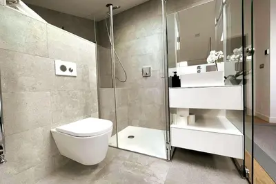 a bathroom with a toilet and a glass shower at H7072 Luxury apartments in Santiago de Compostela