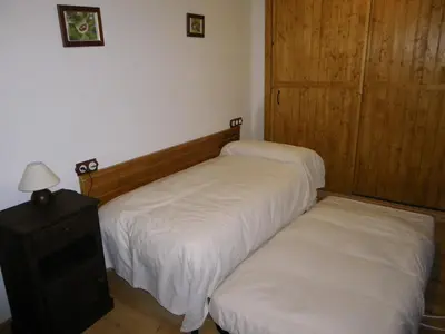 a bedroom with two beds and a nightstand with a lamp at Casa Rural Los Cabritos de Tomás in Puebla de Sanabria