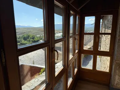 a room with four windows looking out at a view at Casa Rural Los Cabritos de Tomás in Puebla de Sanabria