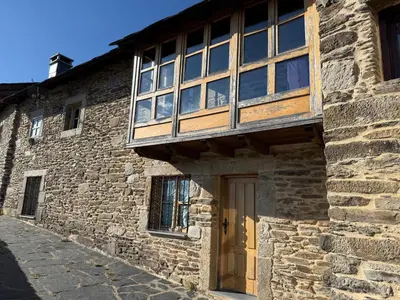 a stone building with a window and a door at Casa Rural Los Cabritos de Tomás in Puebla de Sanabria