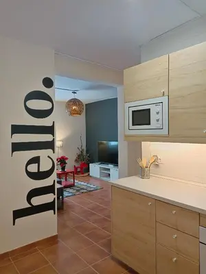 a kitchen with a microwave and a living room at Neverending Nature León in Tremor de Arriba