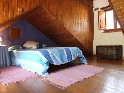 a bedroom with a bed with a wooden ceiling at Casa Trallera in Colinas del Campo de Martín Moro
