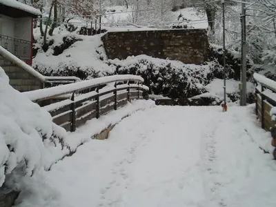 a snow covered path in a yard with benches at Casa Trallera in Colinas del Campo de Martín Moro