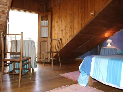 a bedroom with two chairs and a bed and a window at Casa Trallera in Colinas del Campo de Martín Moro