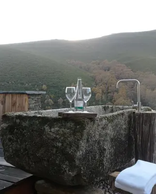 a table with two wine glasses on top of a mountain at Balneario de Calabor in Calabor