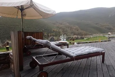 a bed on a deck with an umbrella at Balneario de Calabor in Calabor