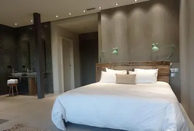 a bedroom with a large white bed with two lamps at Balneario de Calabor in Calabor