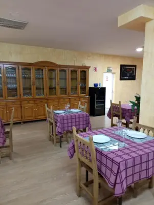 a dining room with purple tables and wooden cabinets at O novo alto do couso in Ourense
