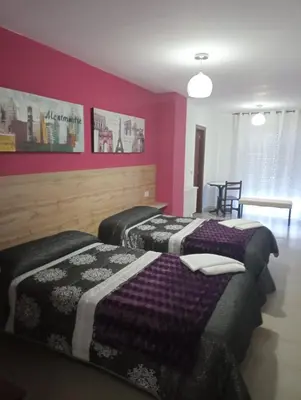 two beds in a room with purple walls at O novo alto do couso in Ourense