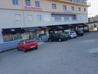 a large building with cars parked in a parking lot at O novo alto do couso in Ourense