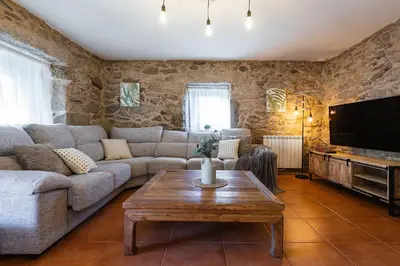 a living room with a couch and a table at Villa Vaquiña in Airoa