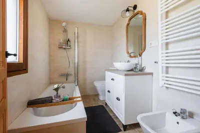 a bathroom with a tub and a sink and a mirror at Villa Vaquiña in Airoa
