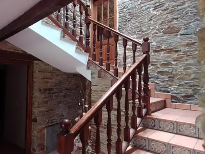 a staircase with a wooden door and a stone wall at Casa Arza in Tríacastela