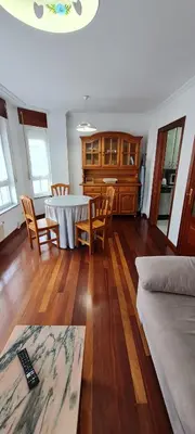 a living room with a table and chairs at Apartamentos Tesón Ribadeo in Ribadeo