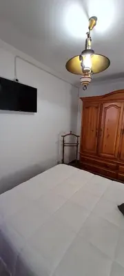 a bedroom with a white bed and a lamp at Apartamentos Tesón Ribadeo in Ribadeo