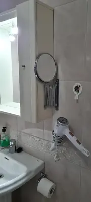 a bathroom with a mirror and a sink at Apartamentos Tesón Ribadeo in Ribadeo