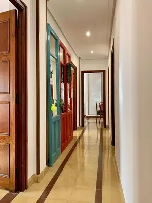 a hallway with a blue door and a table at Alojamiento estilo Boho con mucho encanto in Ponferrada