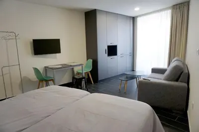 a hotel room with a bed and a chair and a desk at Lumen Place APARTAMENTOS in Mondoñedo