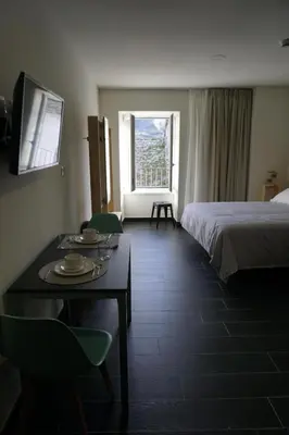a hotel room with a bed and a table with plates on it at Lumen Place APARTAMENTOS in Mondoñedo
