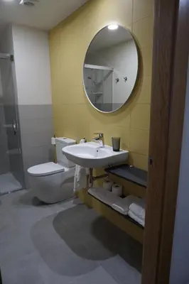 a bathroom with a sink and a toilet and a mirror at Lumen Place APARTAMENTOS in Mondoñedo