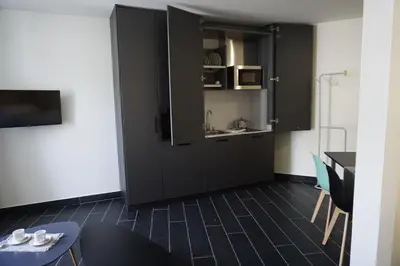 a kitchen with a black cabinet and a table at Lumen Place APARTAMENTOS in Mondoñedo