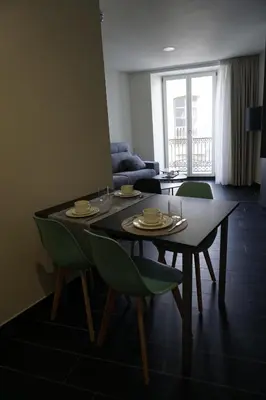 a living room with a dining table and chairs at Lumen Place APARTAMENTOS in Mondoñedo