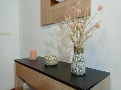 a black table with a vase with flowers in it at Martínez Rooms Pilgrims in Caldas de Reis