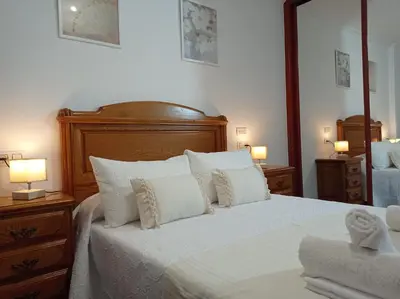 a bedroom with a large white bed with white pillows at Martínez Rooms Pilgrims in Caldas de Reis