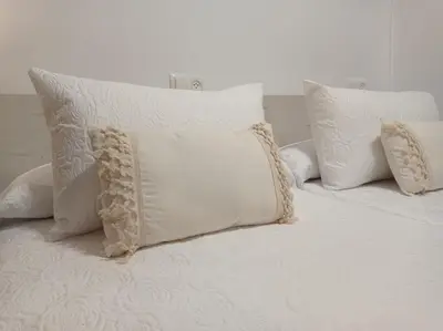 a white bed with white pillows on it at Martínez Rooms Pilgrims in Caldas de Reis