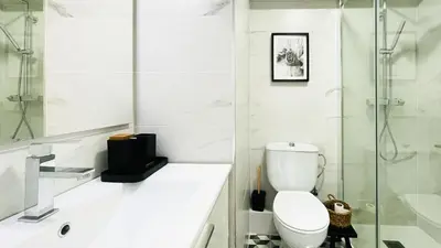 a white bathroom with a toilet and a shower at Apartamento Playa Lago in A Coruña