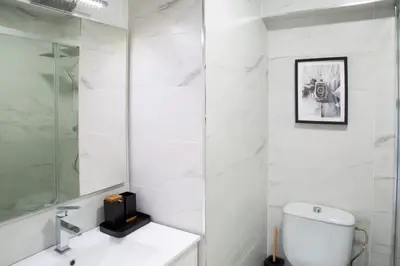 a white bathroom with a toilet and a sink at Apartamento Playa Lago in A Coruña