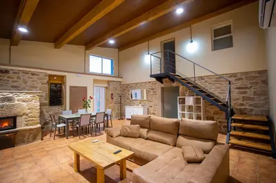 a living room with a couch and a staircase at Casa Peña Dura in Lalín