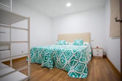 a bedroom with a bed with a blue and white comforter at Casa Peña Dura in Lalín
